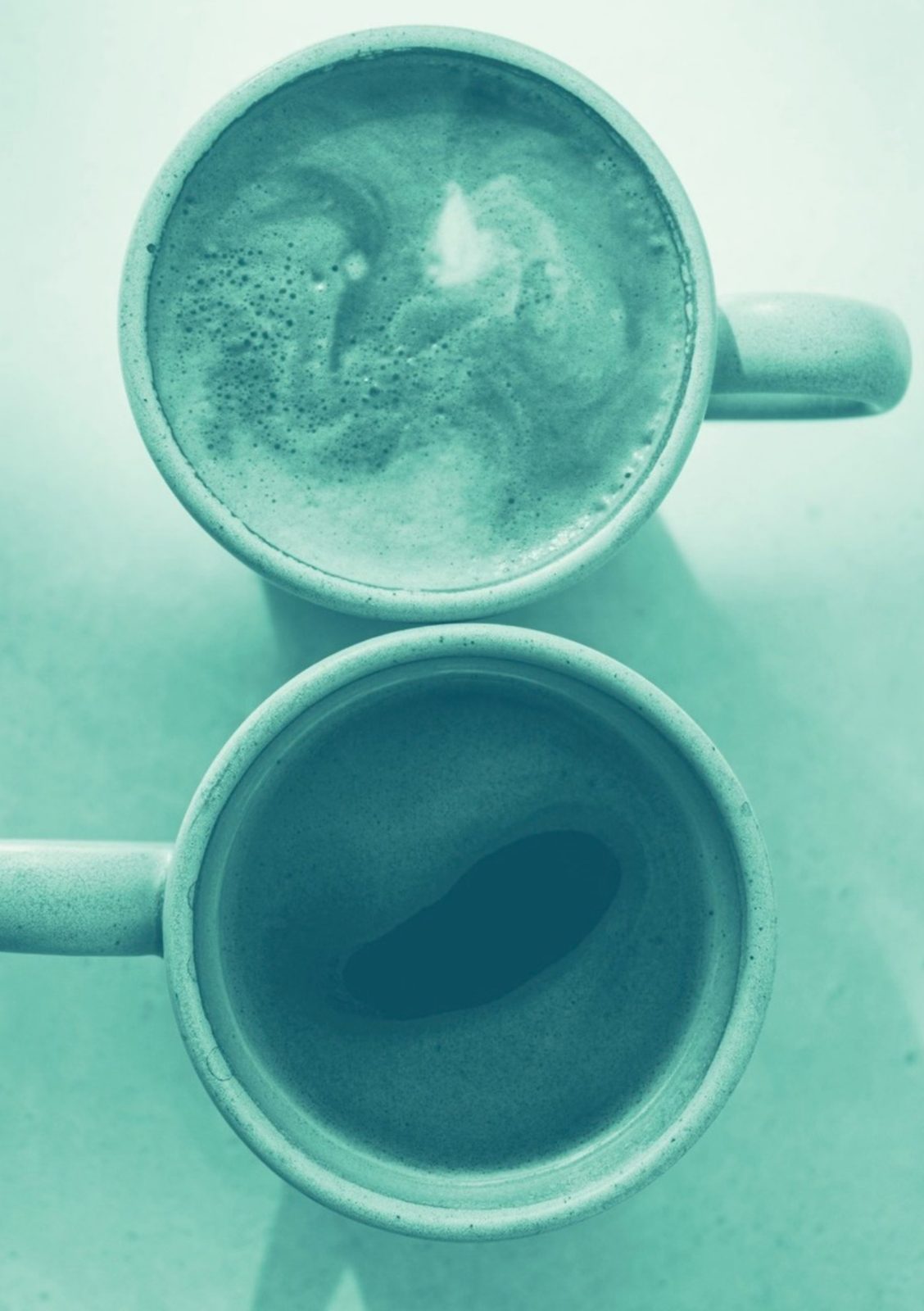 Due tazze di caffè viste dall'alto, una accanto all'altra, in tonalità verde acqua